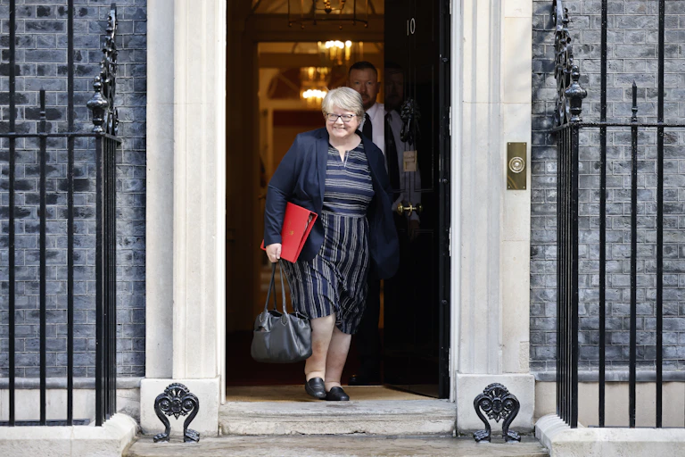 Smiling Therese Coffey walks out of Downing Street with a red folder under her arm, after the first meeting of Truss's cabinet