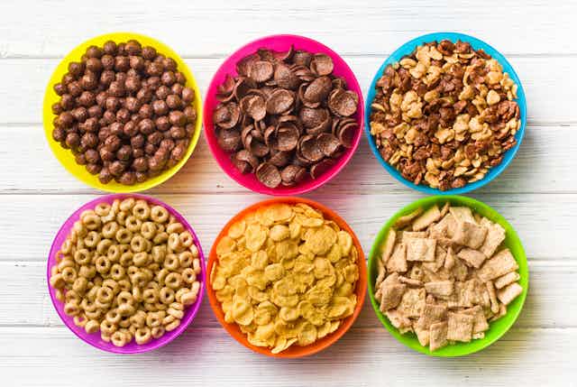 Six bowls of breakfast cereal, many of which are considered ultra-processed foods.