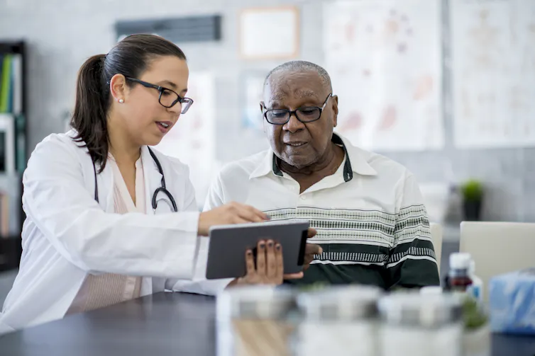 Clinician showing clipboard to patient in exam room