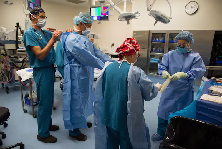 Du personnel soignant, en tenue médicale, se prépare pour une opération
