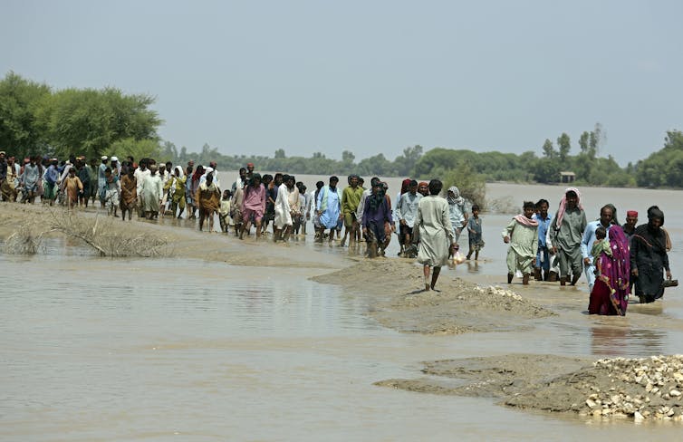 A line of people standing in water.