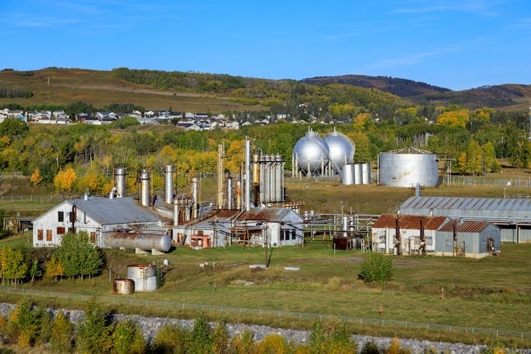 A natural gas facility amid green fields.