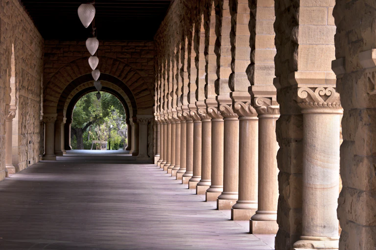 Long, wide corridor flanked by Grecian style columns
