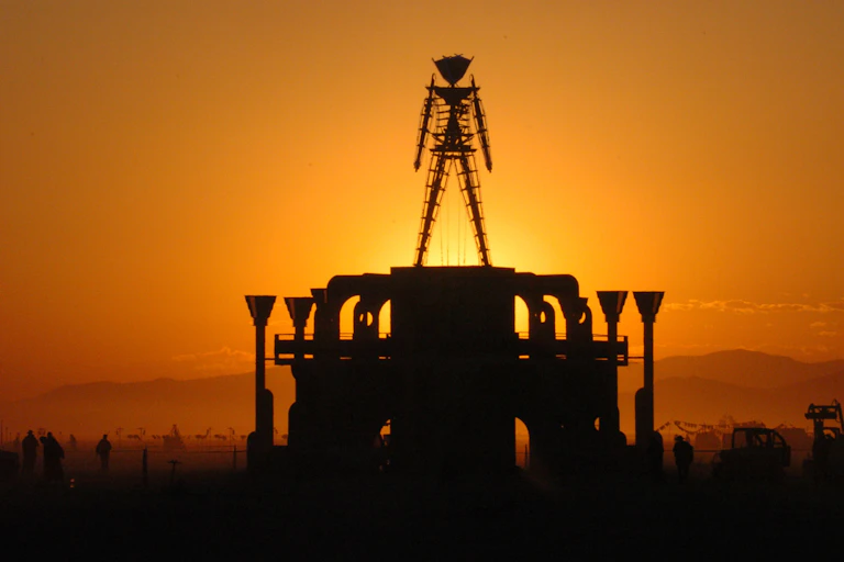 A stick figure of a man silhouetted against a morning sunrise.