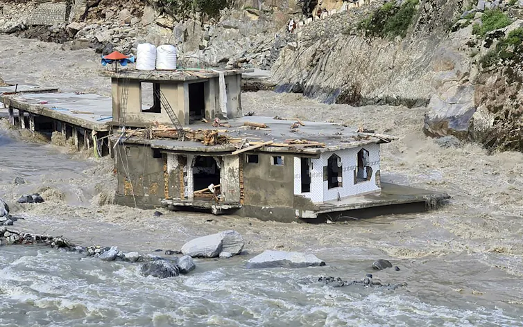 A damaged mosque is surrounded by floodwaters