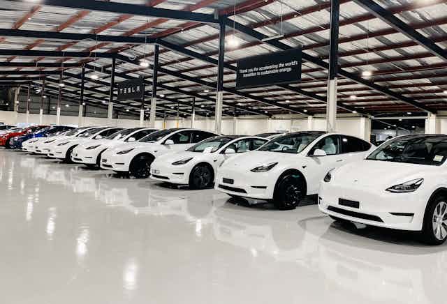 electric cars lined up in a warehouse waiting for delivery