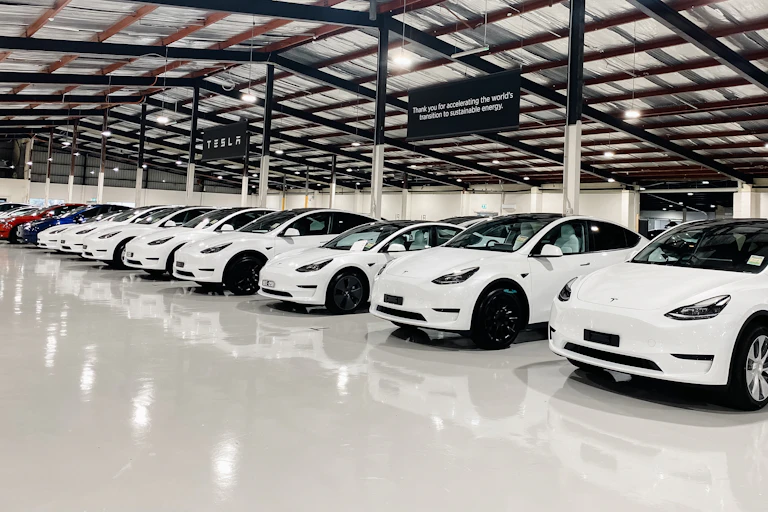 electric cars lined up in a warehouse waiting for delivery