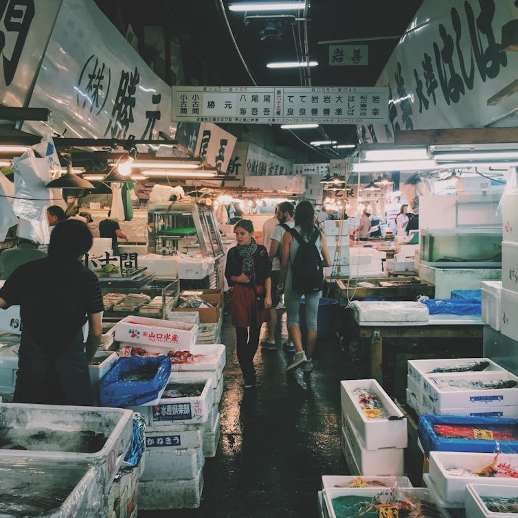 A woman walks through a seafood market.