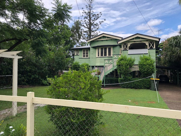 A green house surrounded by trees and shrubs