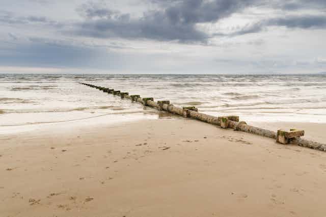 A sewage discharge pipe leading out to sea on a UK beach.