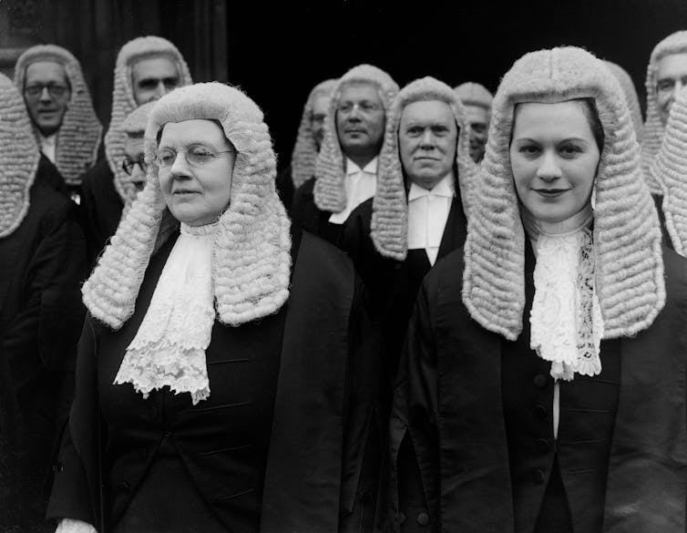 Black and white photo of two women in wigs.