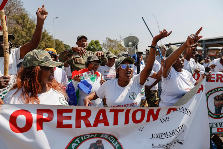 Group of people holding a banner and gesturing