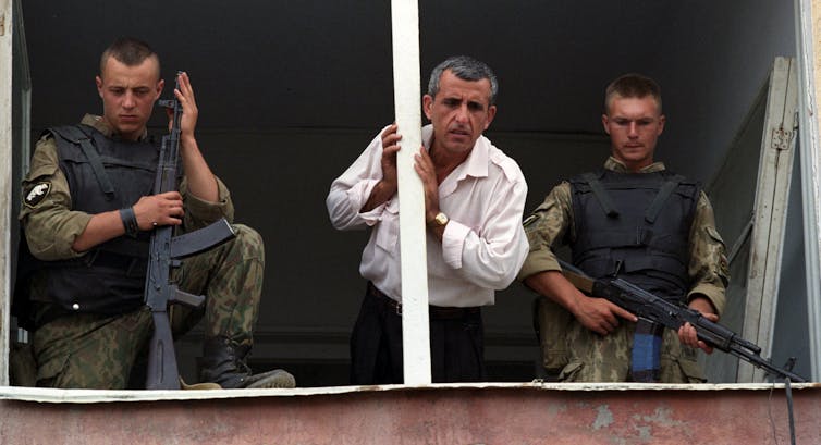 Мужчина разговаривает со своими родственниками во время содержания в так называемых «фильтрационных лагерях» для чеченцев, задержанных с оружием или подозреваемых в других противоправных действиях, Грозный, Чечня, Россия, 7 сентября 1995 г.