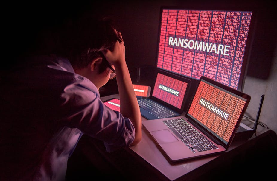 Man stares at computer screen infected by ransomware