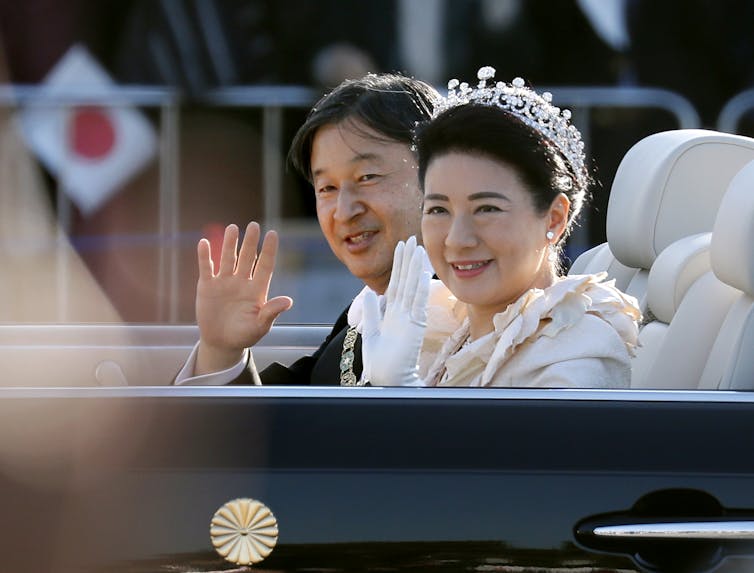 Japan's Emperor Naruhito (L) and Empress Masako (R) wave to well-wishers from a limousine during a parade in Tokyo, Japan, 10 November 2019.