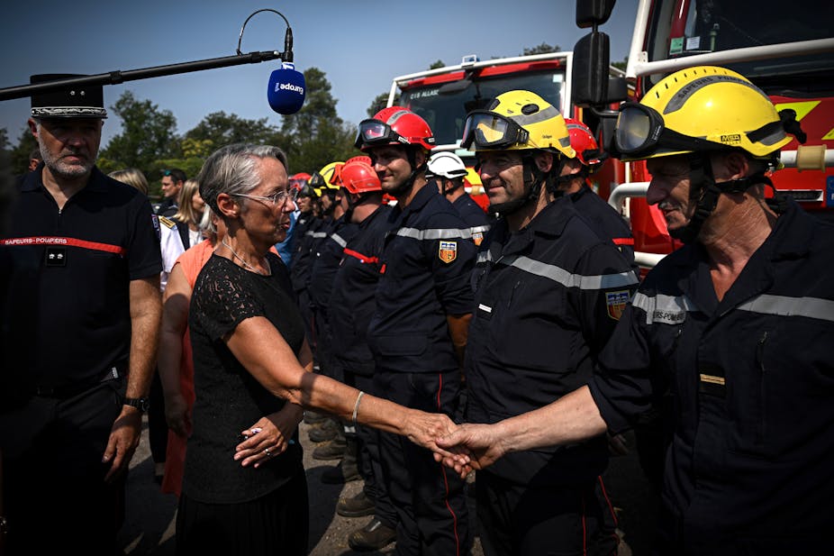 La première ministre française Élisabeth Borne avec des pompiers en août 2022