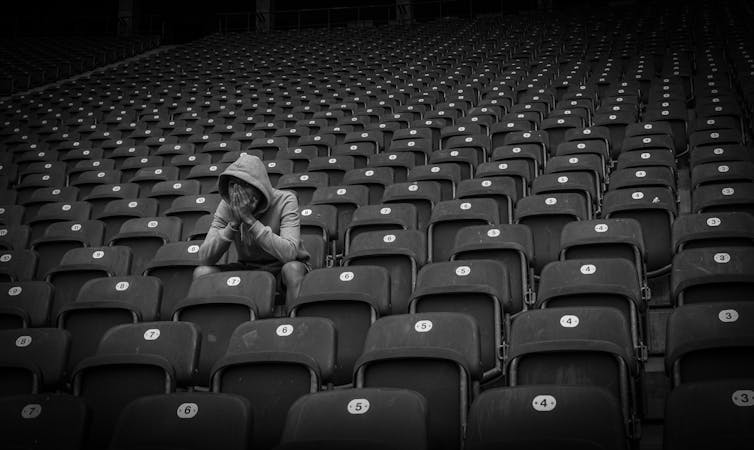 Lone football fan surrounded by empty seats.