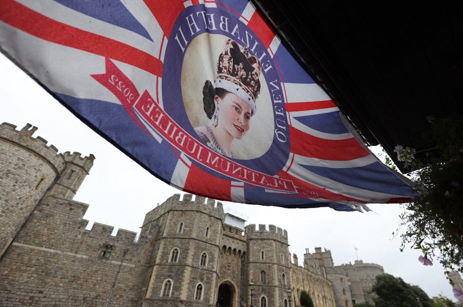 Un drapeau britannique représentant la reine flotte devant le château de Windsor
