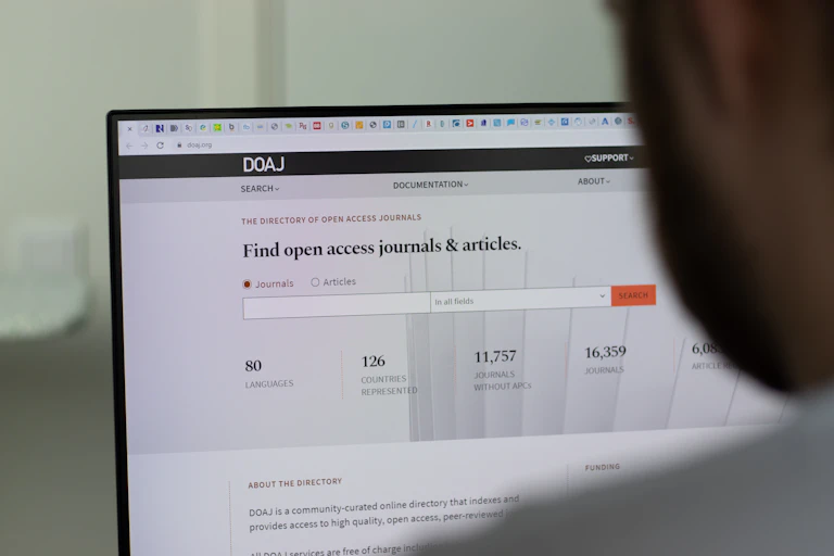 profile of a person looking at a computer screen showing a search bar for open access journals and articles