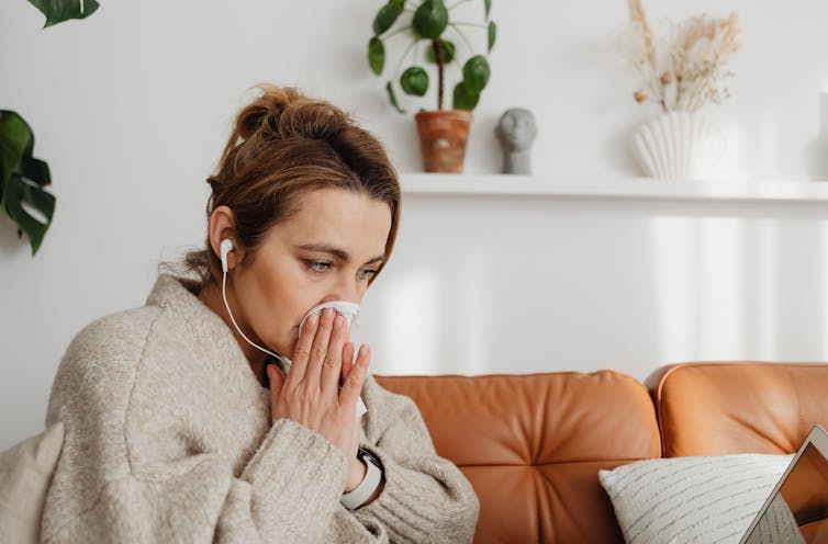 A woman blows her nose.