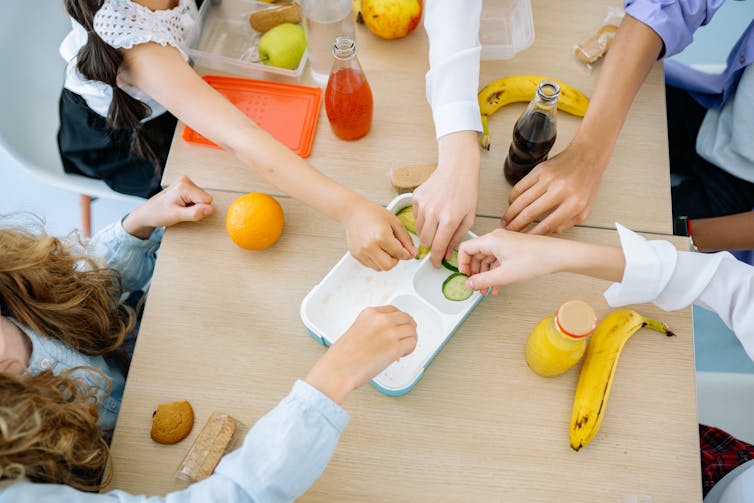 Children eat together around a table.