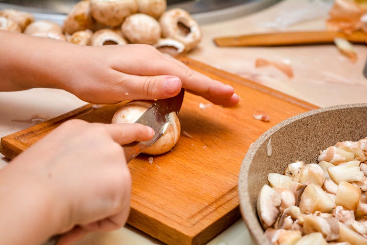 A child chops mushrooms.