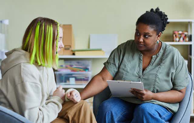 A young person sits with a psychologist.