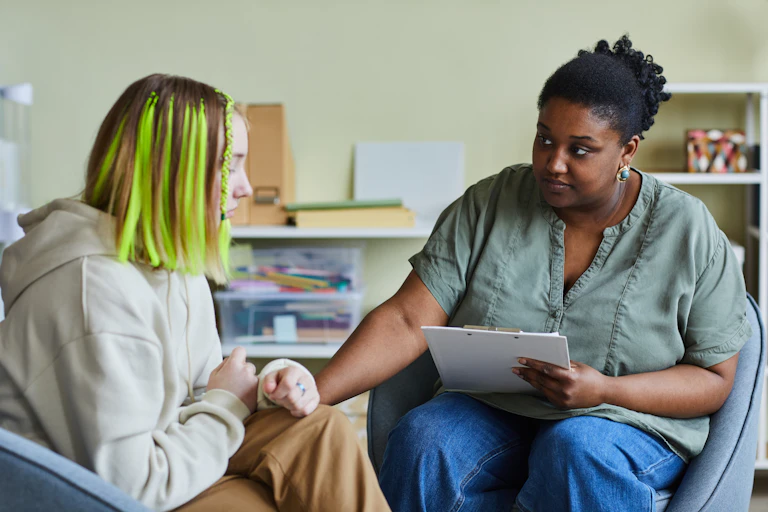 A young person sits with a psychologist.