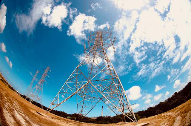 power transmission tower from below with blue sky background