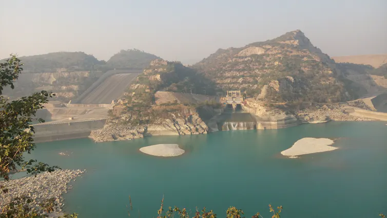 A dam preserving a reservoir in an arid, mountainous region.