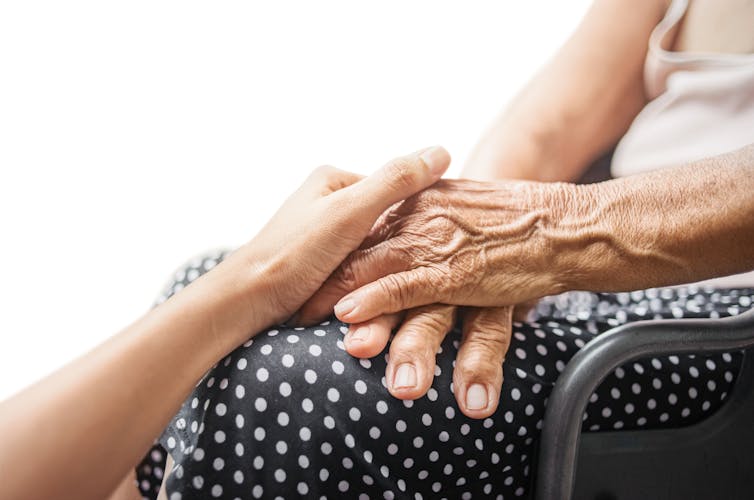 Young hands grasp older hands