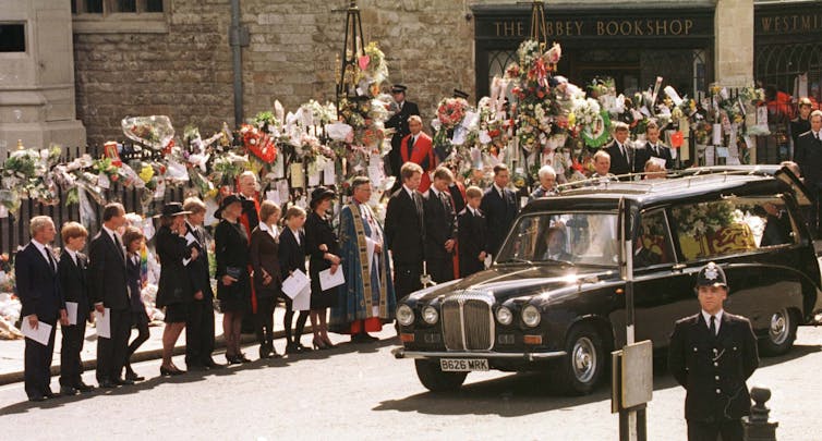 The royal family watch as Princess Diana's coffin is driven by at her funeral.