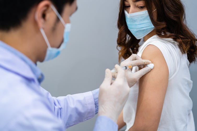 A woman receives a vaccination.