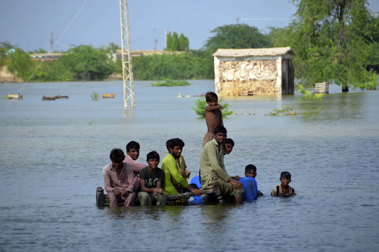 A group of men sit in floodwater in Pakistan's southwestern Balochistan province, Sept. 3, 2022.