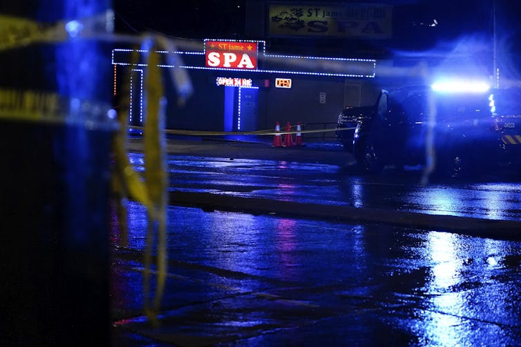 A spa is illuminated at night behind yellow police tape.