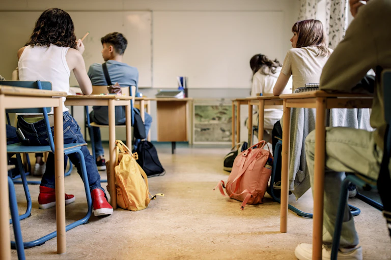 High-school students sitting at desks in classroom