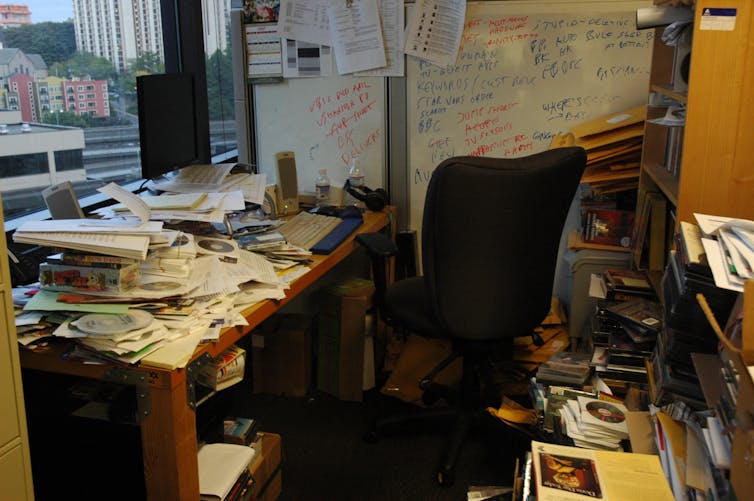 Messy office strewn with piles of paper