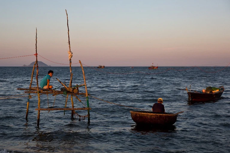 Homme dans une barque sur l'eau au Vietnam