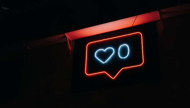 A neon sign with a heart and zero in a speech bubble