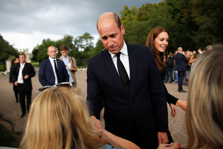 Prince William and Kate Middleton greet the public outside Buckingham Palace.