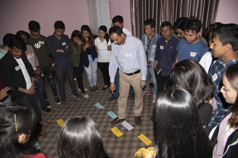Young people look at messages taped to a carpet as they debate issues.