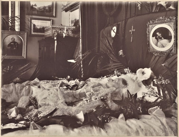 Queen Victoria on her deathbed surrounded by trinkets.