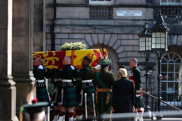 Soldiers carry a coffin.