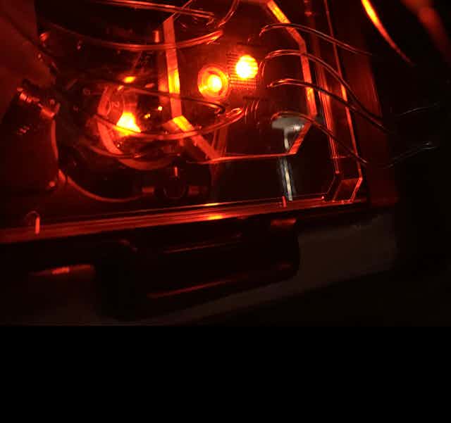 A glowing orange device with tubes going out of it