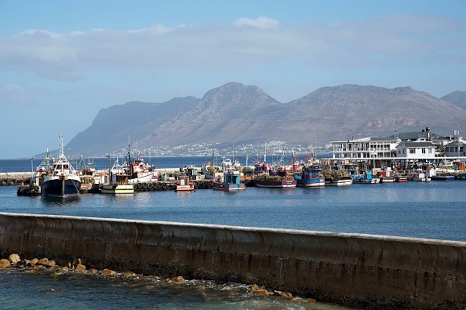 Scene of a harbour with vessels and buildings, mountain in the background