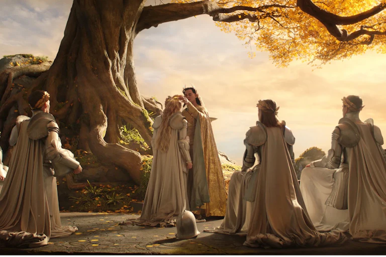 A group of elves kneel during a coronation by a tree.