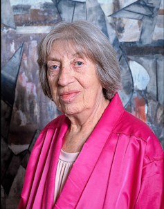 A gray-haired female artist called Lee Krasner in a bright pink satin jacket.