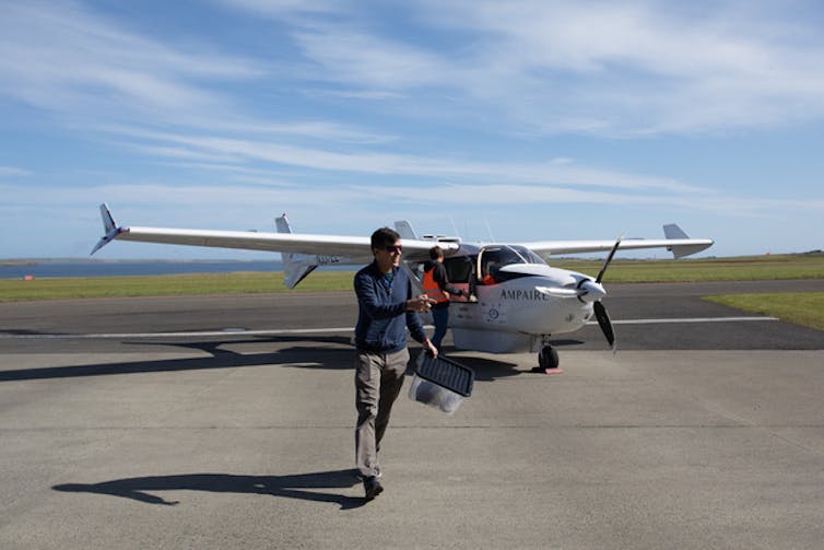 Pilot odchází od malého letadla na letišti; Lety s krátkým skokem můžou fungovat na baterie
