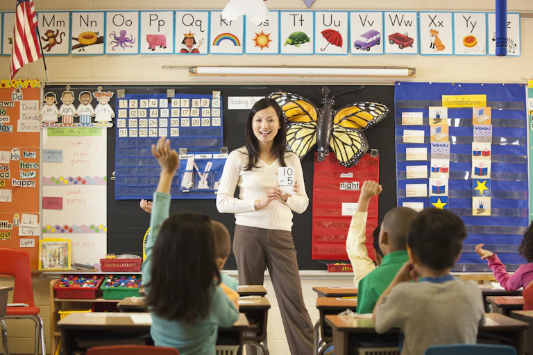 A female teacher leads her elementary school children in a math drill.