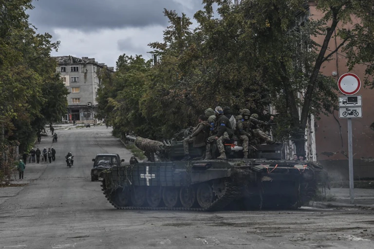 Militaires sur un char dans une ville